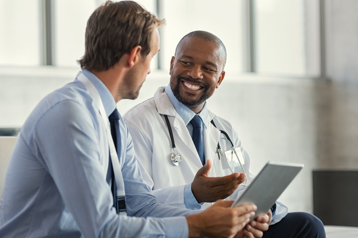 Two professionals in a laboratory setting reviewing findings together on a tablet